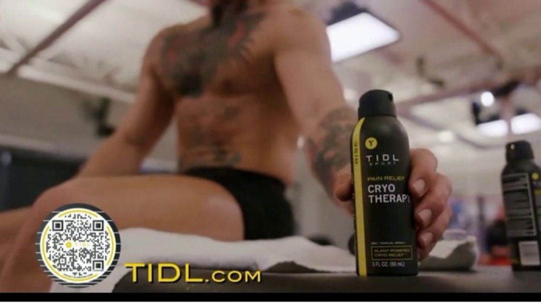 A still from the TIDL TV spot: a fighter holding the cryotherapy spray with an on-screen QR code