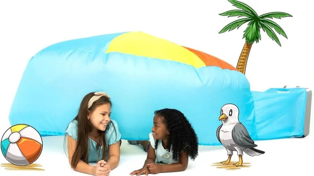 Two kids playing inside an AirFort styled as a beach