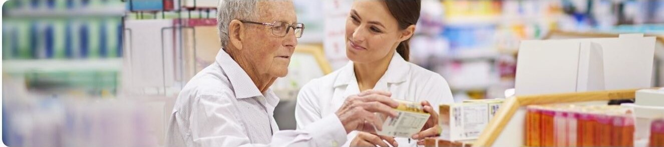 A pharmacist helping an older customer read a product package