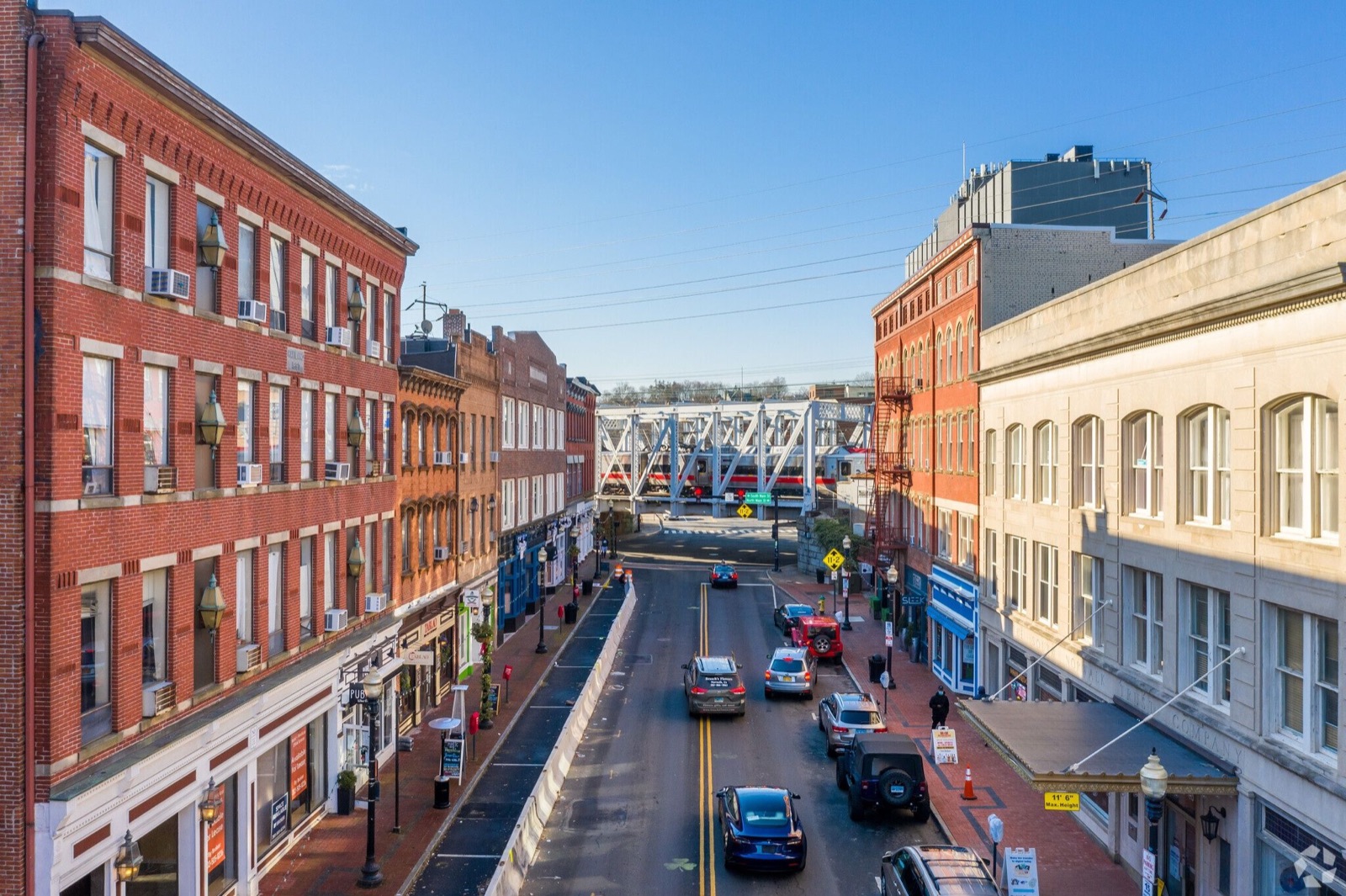 Washington Street in South Norwalk, Connecticut, with a Metro-North train crossing the bridge at the end of the street
